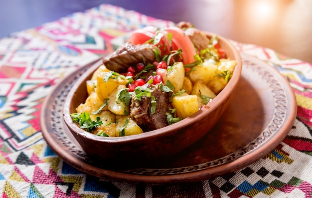 Patatas fritas con trozos de carne en una cazuela de barro. Cocina europea.