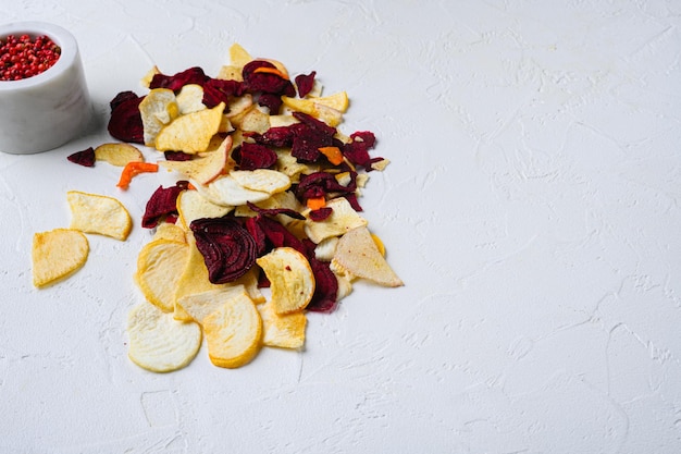 Patatas fritas de verduras secas sobre fondo de mesa de piedra blanca con espacio de copia para texto