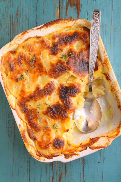 Patatas gratinadas con leche, cebolla y tocino.