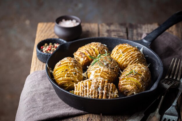 Patatas hasselback al horno con queso, ajo y verduras