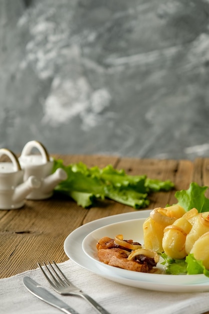 Patatas hervidas con chicharrones comida casera y cocina en una mesa de madera utensilios blancos