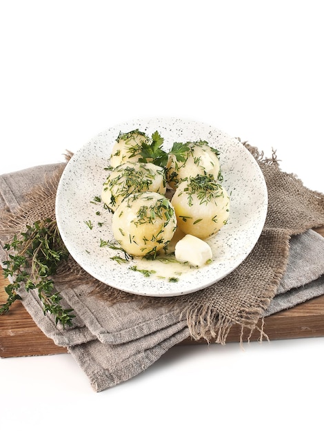 Patatas hervidas con eneldo y mantequilla sobre fondo blanco aislado