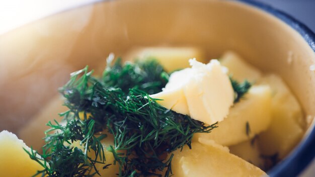 Patatas hervidas en una sartén con eneldo.