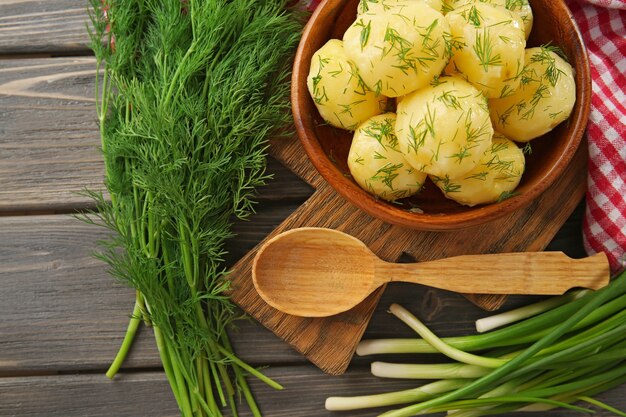 Patatas hervidas con verduras en un recipiente sobre la mesa