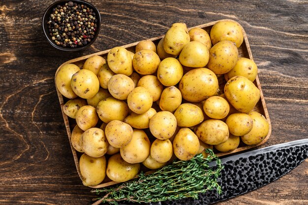 Patatas jóvenes enteras en una bandeja de madera