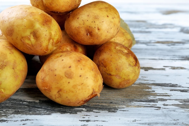 Patatas jóvenes en la mesa de madera de cerca