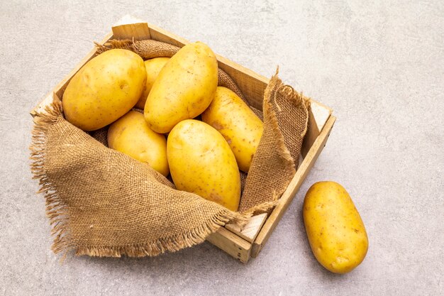 Patatas jóvenes sin pelar crudas en una caja de madera