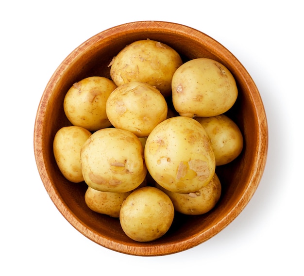 Patatas jóvenes en un plato de madera sobre una vista superior de fondo blanco