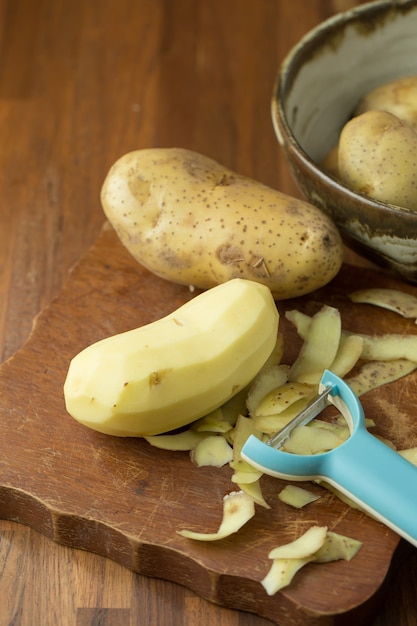 Patatas y patatas en rodajas en la mesa de madera. Enfoque selectivo