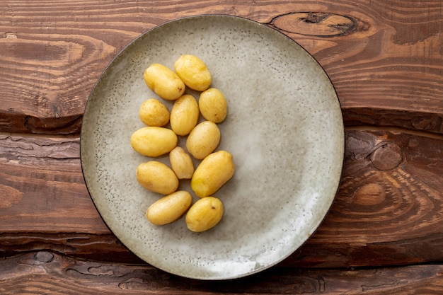 Patatas pequeñas hervidas en un plato sobre un fondo de madera.