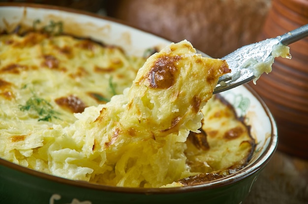 Patatas Romanoff, horneadas con crema agria, cebollas verdes y queso procesado, cocina clásica rusa del siglo XIX, platos variados, vista superior.