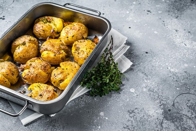 Patatas rotas al horno con romero y tomillo Fondo gris Vista superior Espacio de copia