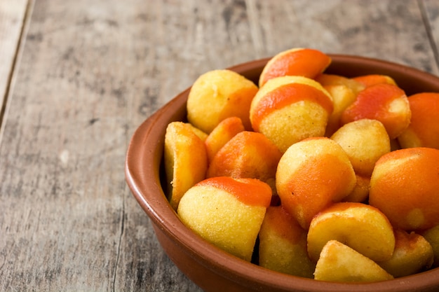 Patatas en un tazón en la mesa de madera