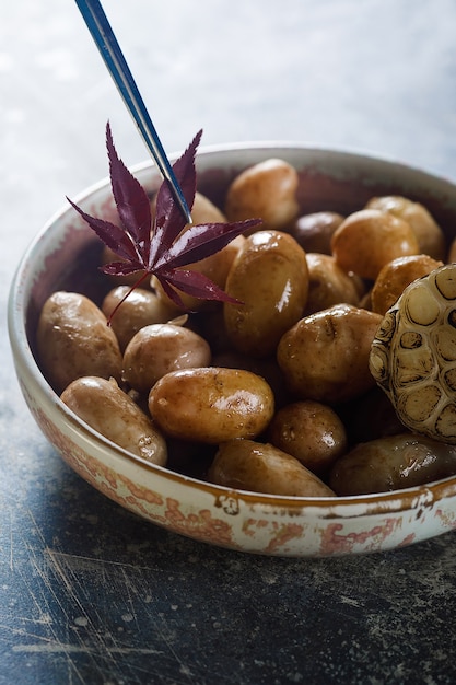 Foto patatas tiernas hervidas con aceite y ajo asado, en un plato de madera