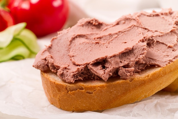 Paté de carne de hígado untado en pan blanco sobre un fondo claro desayuno primer plano sin gente enfoque selectivo pasticcio pastete