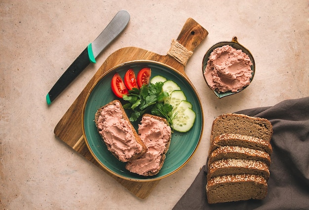 Paté de carne de hígado untado en pan de centeno desayuno primer plano fondo beige sin gente enfoque selectivo