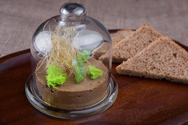 Patê de foie gras com ervas e pão sob cúpula de vidro