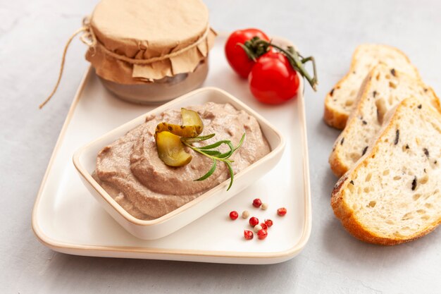 Paté de hígado de pollo casero con pepino en escabeche y tomate y pan integral crujiente fresco