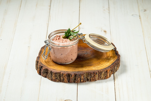 Paté de hígado de pollo en un frasco de vidrio con tablero de madera