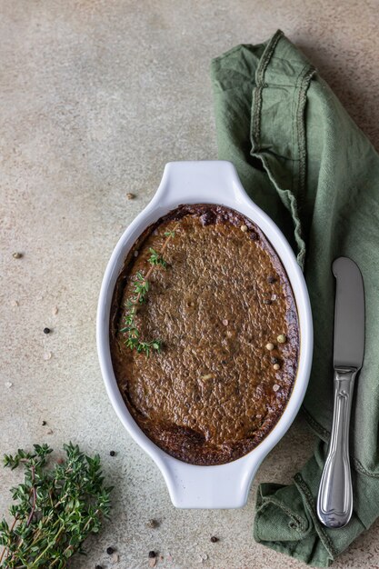 Paté de hígado de pollo o pavo al horno o soufflé en molde de cerámica con tomillo. Vista superior.