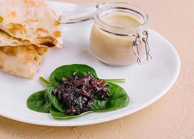 pate de pollo con mermelada de cebolla y pan pita servido en un plato blanco