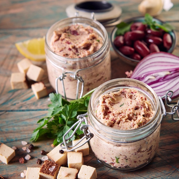 Paté vegetariano en tarros servido en mesa con ingredientes