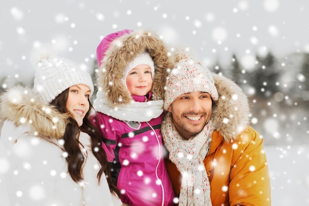 Paternidade, moda, estação e conceito dos povos - a família feliz com a criança no inverno veste-se fora