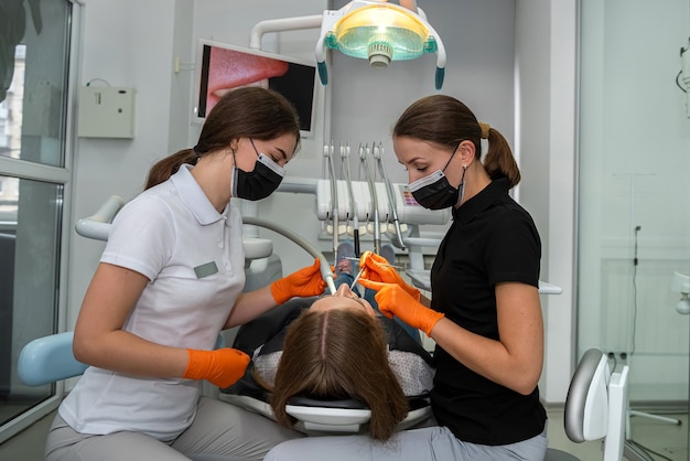 Patient bei der Überprüfung bei jungem Zahnarzt in der Klinik. Gesunde Zähne und Medizinkonzept