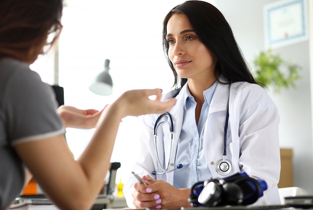 Patient, der mit reifem kaukasischem GP in ihrem Büro spricht