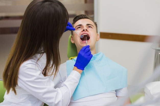 Foto patient, der zähne vom zahnarzt überprüfen lässt