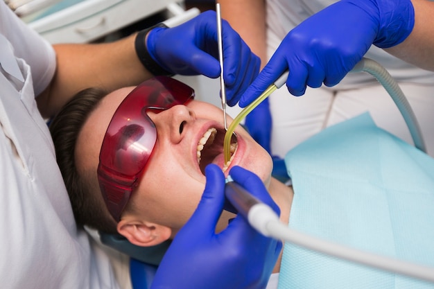 Patient, der zahnmedizinische Prozedur durch Zahnärzte erhält