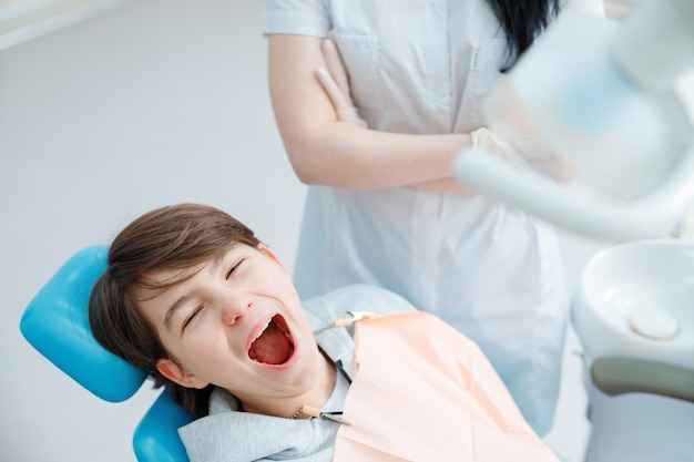 Patient im Zahnarztstuhl Teen Boy mit Zahnbehandlung in der Zahnarztpraxis