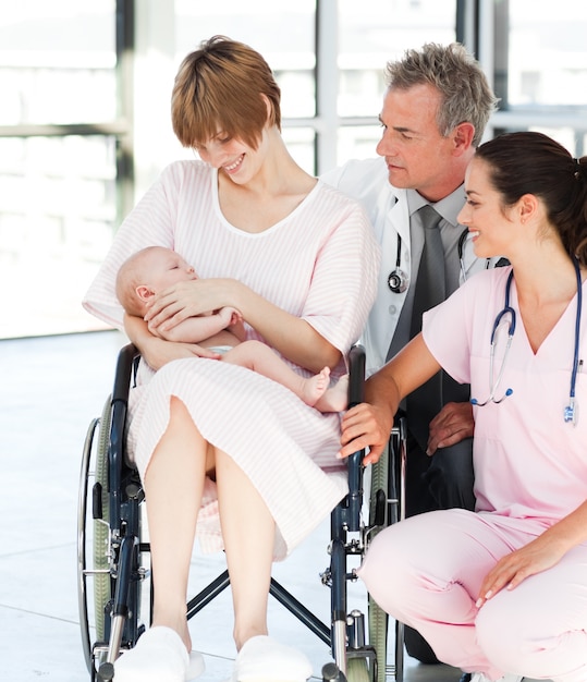 Patient mit ihrem neugeborenen Baby und Doktoren