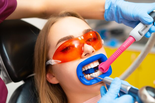 Patient mit Schutzbrille vor UV-Licht mit Tubulus im Mund