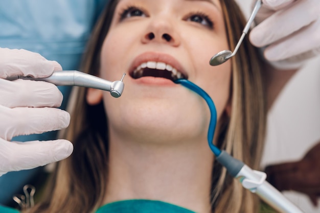 Patientin in Zahnklinik, die von einem männlichen Zahnarzt untersucht wird