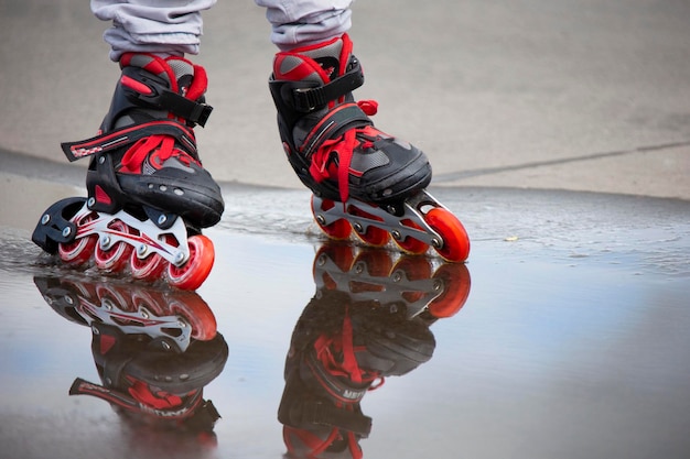 Patinação Pernas em patins passam por uma poça