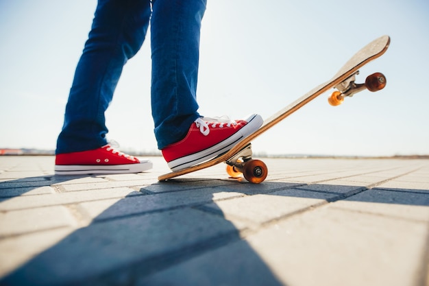 Patinador y sus pies en una patineta