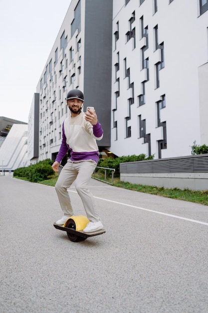 Patinador usando teléfono inteligente al aire libre Hombres de estilo colorido Fondo urbano Foto de alta calidad