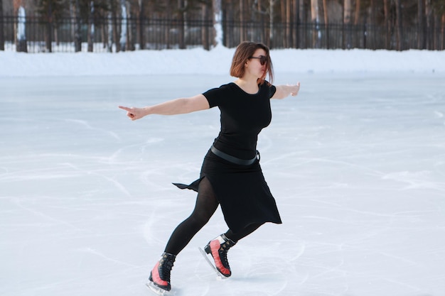 Patinadora artística no gelo. a garota está patinando. gelo sob o céu aberto. sem maquiagem no inverno, bochechas vermelhas