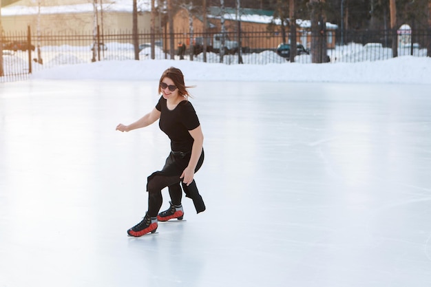 Patinadora artística sobre hielo. la niña está patinando. hielo bajo el cielo abierto. Sin maquillaje en invierno, mejillas rojas