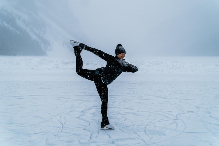 Foto patinadora de hielo patinando en un lago congelado afuera en una tormenta de nieve cerca de un bosque en canadá