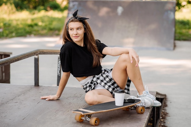 Patinadora con patineta relajándose en la pista de patinaje