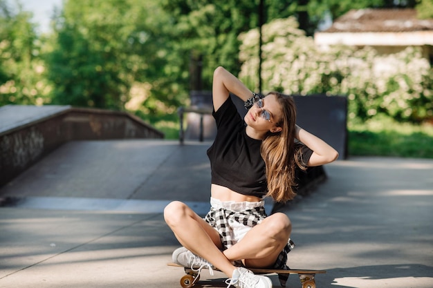 Patinadora con patineta relajándose en la pista de patinaje