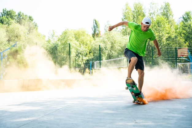 Patinadores com bombas de fumaça coloridas. Skatistas profissionais se divertindo na pista de skate