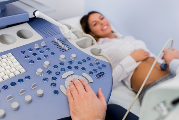 Foto patinet femenino joven tiene ulstrasound examen del abdomen en el hospital