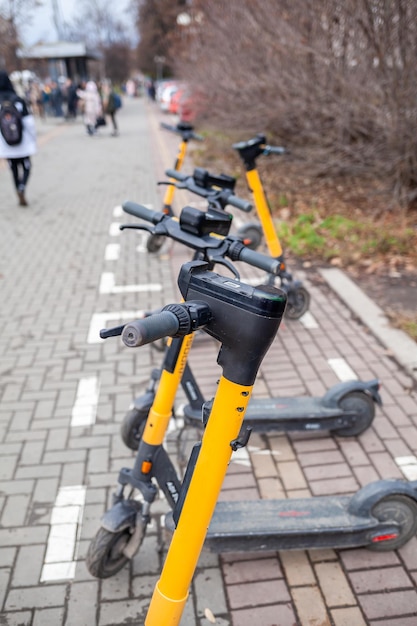 Patinetes elétricas para uso público, paradas em uma rua da cidade, transporte público móvel.