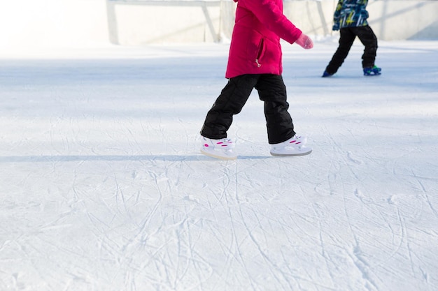 Patins deslizantes de plástico infantil com ajuste de tamanho close-up no gelo no inverno ao ar livre. rolando e deslizando em um dia ensolarado e gelado, esportes de inverno ativos e estilo de vida