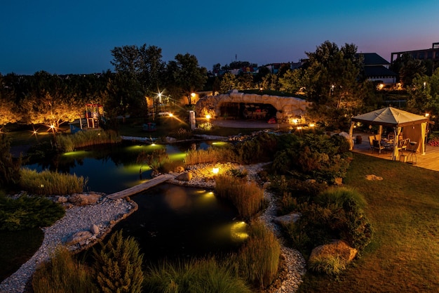 Patio de casa de campo con patio y estanque artificial con iluminación en las noches de verano