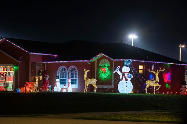 Patio delantero con adornos navideños brillantemente iluminados Decoración exterior de la casa familiar de florida para las vacaciones de invierno