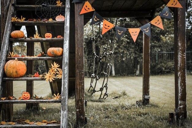 Patio de diseño de Halloween con hojas secas de otoño Hermoso porche de madera de la casa con calabazas en otoño